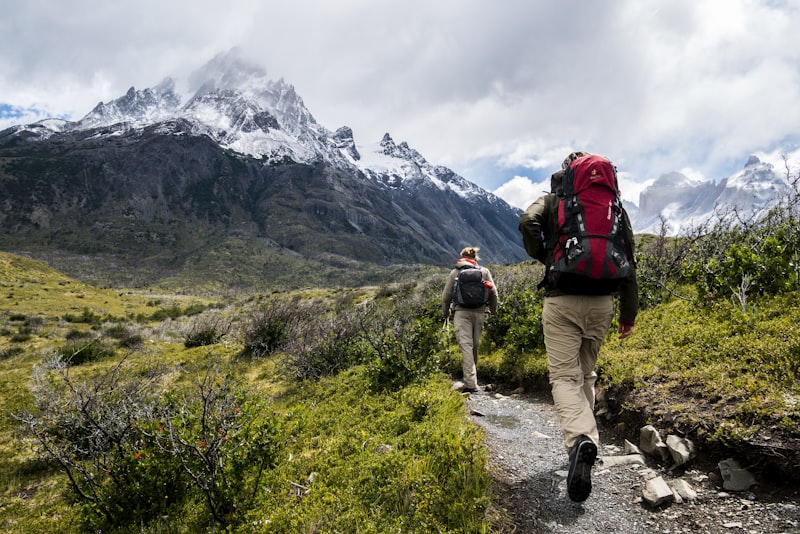 Two hikers with backpacks on a mountain summit at sunrise